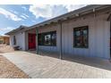 Charming single-story home with a grey exterior, covered walkway, and a red front door at 6810 E Almeria Rd, Scottsdale, AZ 85257