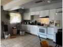 Well-equipped kitchen features white cabinets, tile flooring, and modern appliances at 7808 W Clarendon Ave, Phoenix, AZ 85033