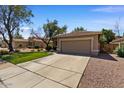 Inviting single-story home with a tidy front yard, a two-car garage, and a long driveway at 8237 W Alex Ave, Peoria, AZ 85382