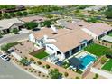 Stunning aerial view of a home with a backyard oasis featuring a pool, spa, outdoor kitchen and seating area at 10520 E Thorite Cir, Mesa, AZ 85212