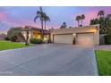 Charming home exterior with a well-maintained lawn, mature palm trees and a spacious driveway at 10658 E Cinnabar Ave, Scottsdale, AZ 85258