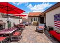 Inviting back patio with brick pavers, comfortable seating under red umbrellas, and great outdoor living space at 14247 N 2Nd Ave, Phoenix, AZ 85023