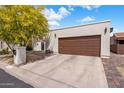 Exterior view of home featuring an attached garage, concrete driveway, and low-maintenance landscaping at 14247 N 2Nd Ave, Phoenix, AZ 85023