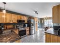Well-lit kitchen featuring wood cabinets, stainless steel appliances, granite counters, and tile flooring at 16103 W Redfield Rd, Surprise, AZ 85379