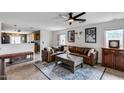 Inviting living room with a ceiling fan, plush leather seating, and tile flooring at 16103 W Redfield Rd, Surprise, AZ 85379
