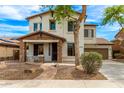 Charming two-story home featuring a stone-accented porch, manicured landscaping, and a welcoming pathway at 18171 W Marshall Ln, Surprise, AZ 85388