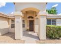 Inviting front entrance featuring an arched doorway and well-maintained landscaping at 1821 N 74Th Pl, Mesa, AZ 85207