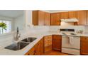 Functional kitchen with stainless steel sink, white countertops, and wood cabinets at 1821 N 74Th Pl, Mesa, AZ 85207