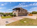 Beautiful home exterior showing a large yard, mature landscaping, and an attached three car garage at 1954 N Calle Maderas --, Mesa, AZ 85213