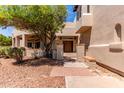 Inviting front entrance features a wood door, brick accents, covered porch, and mature landscaping at 1954 N Calle Maderas --, Mesa, AZ 85213