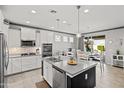 A modern kitchen with white cabinets, stainless steel appliances, and an island with bar seating at 20426 N Blazing Sun Rd, Maricopa, AZ 85138