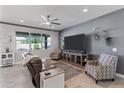 Spacious living room with neutral tones, comfortable seating, ceiling fan, and large windows at 20426 N Blazing Sun Rd, Maricopa, AZ 85138