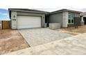 Exterior of a new home with a grey brick driveway and an attached garage at 22709 E Saddle Way, Queen Creek, AZ 85142