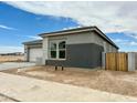 Well-lit exterior showcases the modern gray stucco, landscaped yard and the side gate of this single-Gathering home at 22709 E Saddle Way, Queen Creek, AZ 85142