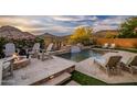 Backyard pool with waterfall, lounge chairs, and fire pit for outdoor enjoyment at 27276 N 81St Ln, Peoria, AZ 85383