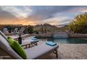 Relaxing pool area with lounge chairs, side table with wine, and waterfall feature at 27276 N 81St Ln, Peoria, AZ 85383