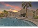 A beautiful backyard featuring a sparkling pool, patio seating, and lush desert landscaping at 40061 W Novak Ln, Maricopa, AZ 85138