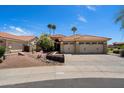 Charming single-story home featuring desert landscaping, palm trees, and a three-car garage at 4625 E Villa Maria Dr, Phoenix, AZ 85032
