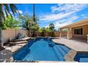 Stunning backyard pool and spa surrounded by lush tropical landscaping with blue skies overhead at 4625 E Villa Maria Dr, Phoenix, AZ 85032