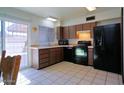 Charming kitchen featuring tile floors, brown cabinets, and black appliances at 4625 W Thomas Rd # 71, Phoenix, AZ 85031