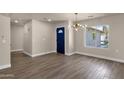 Bright entryway with wood-look tile, striking blue door, and stylish light fixture at 4913 E Acoma Dr, Scottsdale, AZ 85254