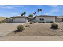 Charming single-story home featuring desert landscaping, palm trees, and American flag at 4913 E Acoma Dr, Scottsdale, AZ 85254