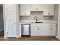 New stainless steel dishwasher and faucet against a backdrop of white cabinets and countertops at 5336 W Lewis Ave, Phoenix, AZ 85035
