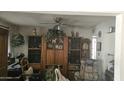 Cozy living room with a large display cabinet, comfortable chair, and a ceiling fan at 6725 W Colter St, Glendale, AZ 85303