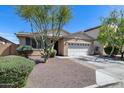 Charming single-story home featuring a well-maintained front yard, two-car garage, and desert landscaping at 7634 W Redbird Rd, Peoria, AZ 85383