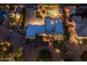 Aerial view showcases a home's pool, manicured yard, and circular driveway at night at 8675 S College Ln, Tempe, AZ 85284