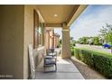 Cozy covered front porch with comfortable seating and a view of the neighborhood at 9829 E Talon Ave, Mesa, AZ 85212