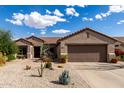 Charming single-story home showcasing desert landscaping, a tile roof and two-car garage at 15691 W Arbor Trl, Surprise, AZ 85374