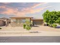 Beautiful single-Gathering home with desert landscaping, a three-car garage, and blue sky at sunset at 16448 W Tether Trl, Surprise, AZ 85387