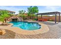 Backyard pool with rock waterfall, slide and hot tub, set in lush landscaping, perfect for outdoor entertaining at 21337 E Waverly Dr, Queen Creek, AZ 85142