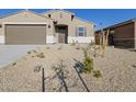 Attractive single-story house with low maintenance desert landscaping and a two-car garage under a clear blue sky at 22514 W Tonopah Dr, Surprise, AZ 85387