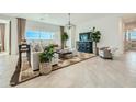 Bright living room featuring a large sectional, modern lighting, and backyard views at 23038 E Nightingale Rd, Queen Creek, AZ 85142