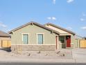 Charming single-story home with a red door and a well-maintained, low maintenance front yard on a sunny day at 2668 E San Miguel Dr, Casa Grande, AZ 85194