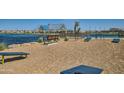A serene lakeside view featuring park benches and covered seating, ideal for relaxing and enjoying the waterfront at 2952 E Lucky Horseshoe Ln, San Tan Valley, AZ 85140