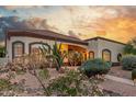 Lovely home with a colorful desert garden, stucco exterior, and beautiful sunset at 3001 E Winchcomb Dr, Phoenix, AZ 85032