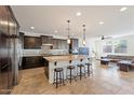 Spacious kitchen featuring a large island with seating, modern appliances, and dark wood cabinets at 3394 E Tiffany Ct, Gilbert, AZ 85298