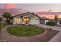 Beautiful home at dusk with manicured yard, a two-car garage, and scenic desert landscaping at 3971 E Heather Ct, Gilbert, AZ 85234