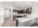 Well-lit kitchen with stainless steel appliances, dark cabinetry, sleek countertop island, and an open concept design at 4136 W Palace Station Rd, New River, AZ 85087