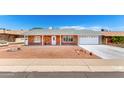 Inviting single-story home with a red brick facade, well-kept yard, and attached garage on a sunny day at 4310 E Sacaton St, Phoenix, AZ 85044