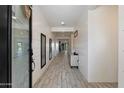 Inviting hallway with light wood-look tile floors and crisp white shiplap walls, leading to the home's interior at 4512 S Ferric Ave, Mesa, AZ 85212