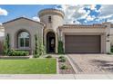 Beautiful single Gathering home featuring a two-car garage, well-manicured lawn, and circular turret entry at 5653 E Sayan St, Mesa, AZ 85215
