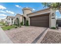 Charming single Gathering home featuring a two-car garage, circular turret entry, and block paved driveway at 5653 E Sayan St, Mesa, AZ 85215