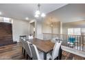 Open-concept dining room featuring a large wood table with white chairs and hardwood floors at 5826 W Plum Rd, Phoenix, AZ 85083