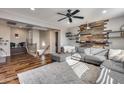Spacious living room with a modern accent wall, hardwood floors, and comfortable gray sectional at 5826 W Plum Rd, Phoenix, AZ 85083