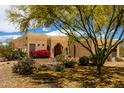 Single story home featuring desert landscaping with blooming flowers, and mature trees at 5978 E Chuckwalla Trl, Cave Creek, AZ 85331
