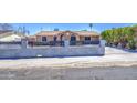 View of the home from the street with a concrete fence and wrought iron gate at 6939 W Cambridge Ave, Phoenix, AZ 85035